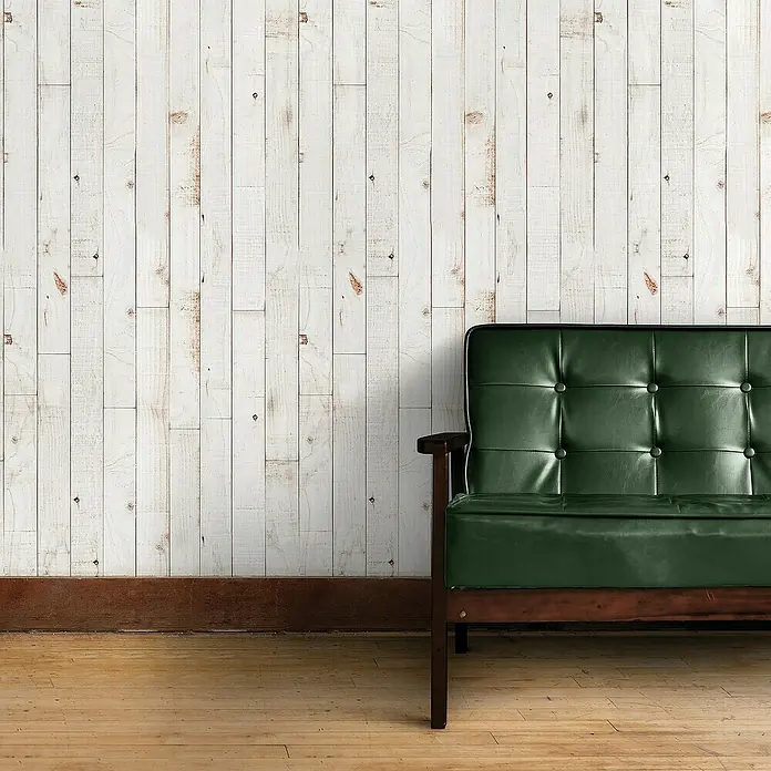 Papel pintado de vinilo autoadhesivo Madera - Blanco, L x An: 280 x 65 cm - Interior elegante con sofá de cuero verde sobre pared rústica de paneles de madera, creando un ambiente acogedor y agradable.
