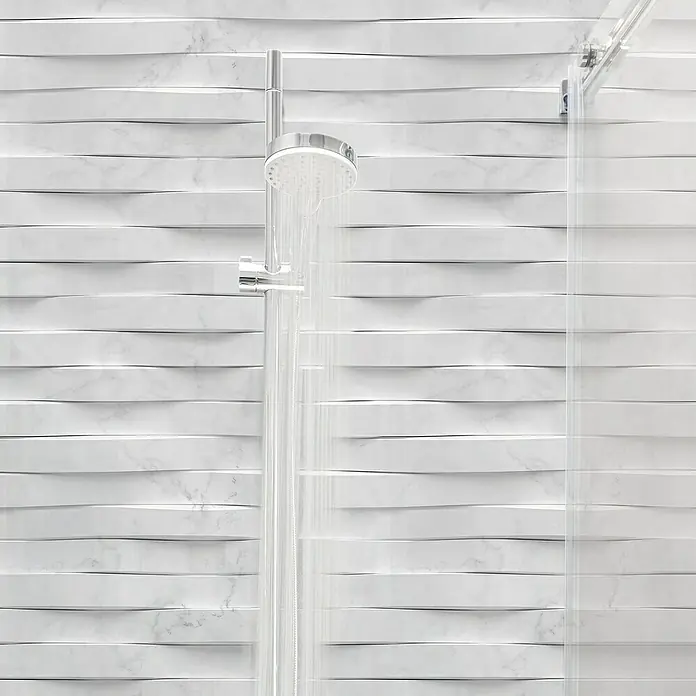 Papel pintado de vinilo autoadhesivo Carrara - Blanco, L x An: 280 x 65 cm - Ducha moderna con cabezal de ducha plateado y puertas de vidrio transparente sobre un fondo de azulejos horizontales ondulados. Elegante diseño de baño.