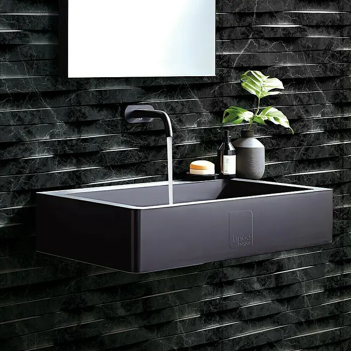 Papel pintado de vinilo autoadhesivo Carrara - Negro, L x An: 280 x 65 cm - Elegante y moderno lavabo en tono oscuro montado en una pared texturizada, con grifo, espejo y elementos decorativos.