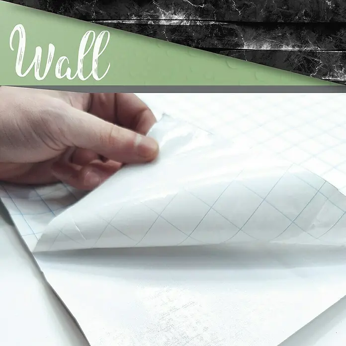 Papel pintado de vinilo autoadhesivo Carrara - Negro, L x An: 280 x 65 cm - Primer plano de una persona que despega papel tapiz de mármol autoadhesivo con líneas de cuadrícula, perfecto para decoración de paredes.