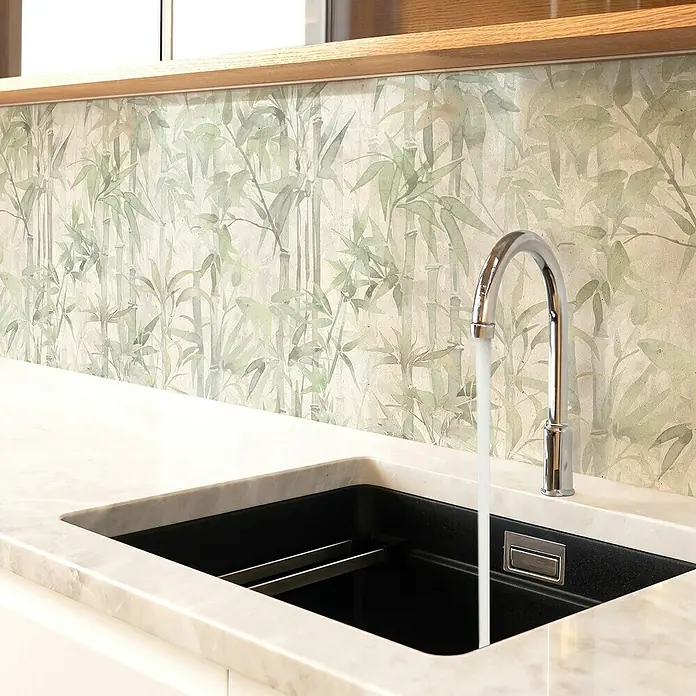 Papel pintado de vinilo autoadhesivo Bamboo - Beige/Verde, L x An: 280 x 65 cm - Primer plano de un fregadero de cocina moderno con un elegante grifo, rodeado de una encimera con textura de mármol y un salpicadero con estampado de bambú.