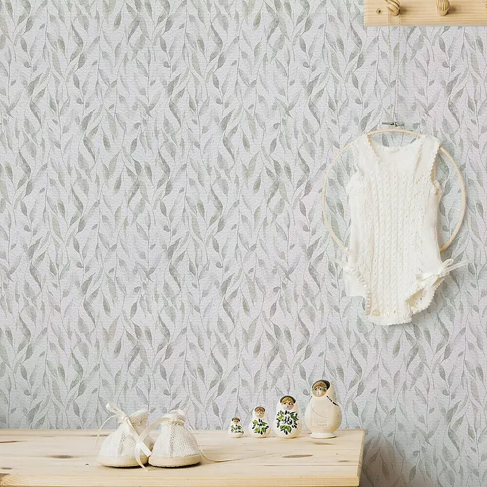 Lámina decorativa autoadhesiva vinílico Premium - 90 x 280 cm, Sauce, Gris - Decoración de habitación de bebé con un body de punto en un aro, zapatos de bebé y muñecas Matrioska sobre una mesa de madera clara contra papel pintado estampado.