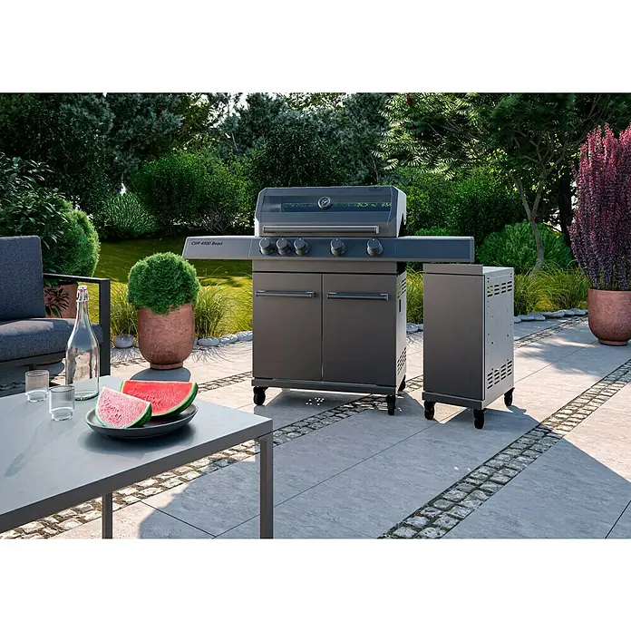 Kingstone Seitenschrank Cliff - Schwarz, B x T x H: 31,2 x 50,9 x 78,2 cm - Ein grauer Gasgrill mit vier Brennern und einem Seitenschrank steht auf einer Terrasse, bereit für ein sommerliches Barbecue im Garten.