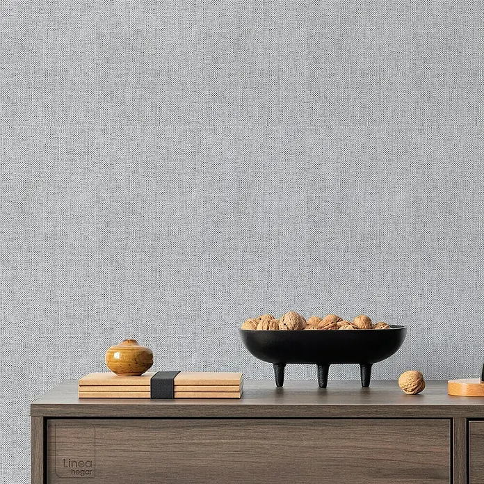 Papel pintado de vinilo autoadhesivo Prato - Gris, L x An: 280 x 65 cm - Primer plano de una mesa decorada con un cuenco negro lleno de nueces, libros y un pequeño tarro sobre una cómoda de madera.