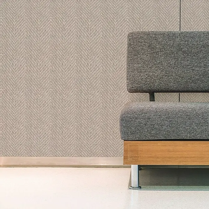 Lámina decorativa autoadhesiva vinílico Premium - 90 x 280 cm, Cima oscuro, Gris - Elegante sofá gris con estructura de madera y patas de metal frente a una pared texturizada. Mueble elegante para espacios modernos.