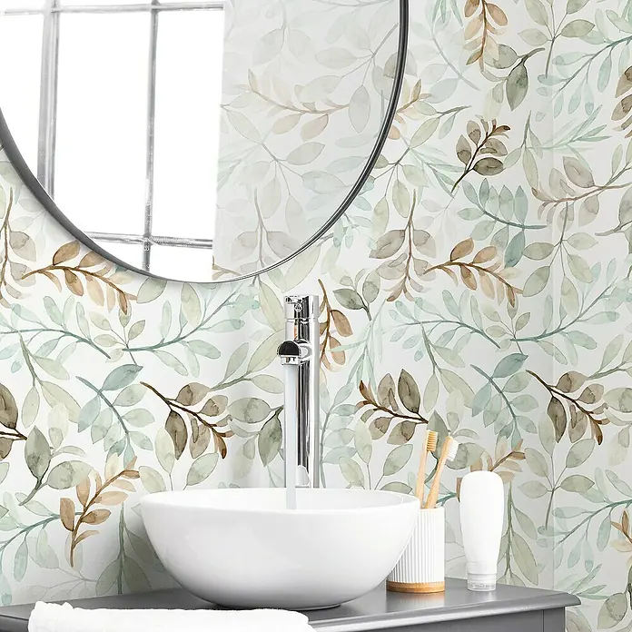 Papel pintado de vinilo autoadhesivo Hojas - Verde, L x An: 280 x 65 cm - Primer plano de un baño con espejo redondo, papel pintado floral, un lavabo con grifo y diversos artículos de aseo.