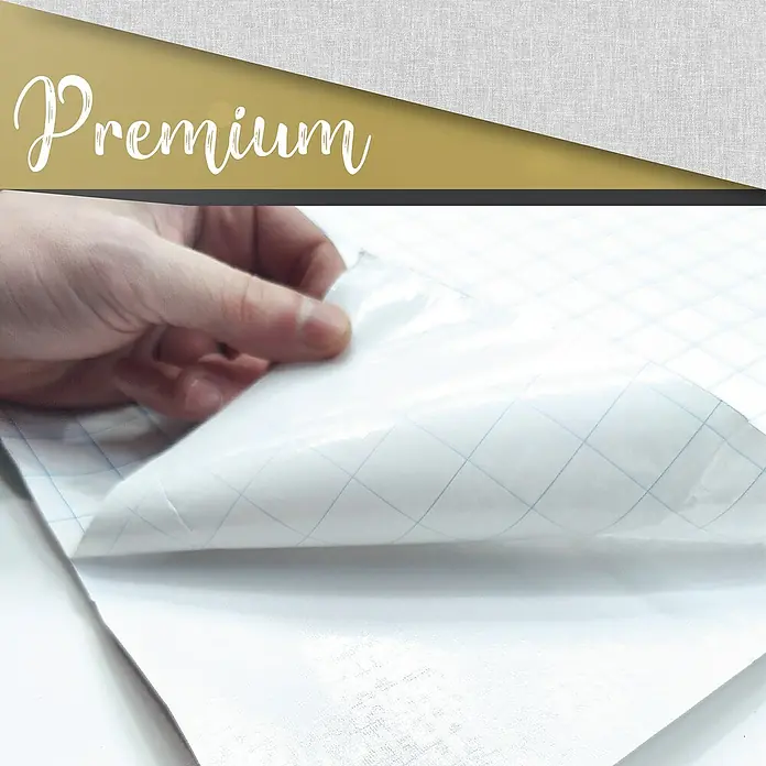 Lámina decorativa autoadhesiva vinílico Premium - 90 x 280 cm, Lienzo, Gris - Primer plano de una lámina de papel de contacto premium con líneas de cuadrícula que está siendo despegada por una mano, ideal para proyectos DIY.