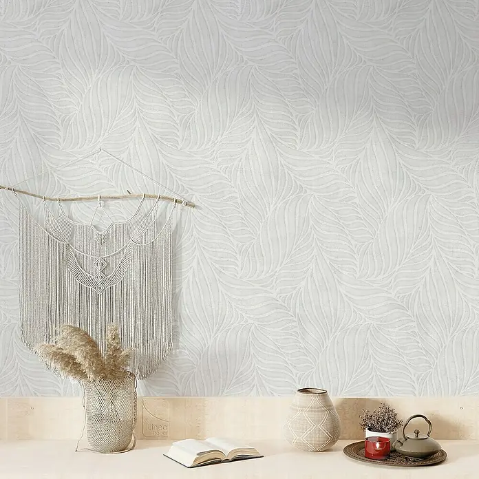 Papel pintado de vinilo autoadhesivo Ojaldre - Gris, L x An: 280 x 65 cm - Primer plano de una pared con papel tapiz blanco con estampado de hojas, creando un ambiente sereno y decorativo.
