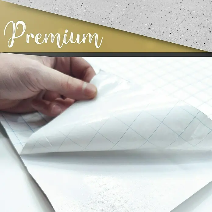 Lámina decorativa autoadhesiva vinílico Premium - 90 x 280 cm, Hormigón, Gris - Primer plano de un trozo de papel transfer premium levantado por una mano, mostrando su textura y calidad.