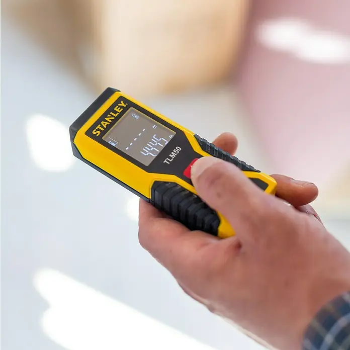 Stanley Medidor de distancia láser TLM50 - Gama de medición: 0,15 m - 15 m - Primer plano de un medidor láser de distancia Stanley TLM50 en mano, que muestra 44,45 metros.