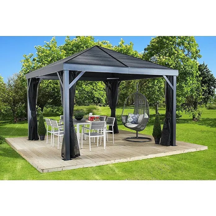 Sojag Standard-Pavillon Premium South Beach 1212 - Basaltgrau, Aluminium, B x T: 364,3 x 364,3 cm - Dunkelgraues Metallpavillon mit schwarzen Mesh-Vorhängen auf Holzdeck, bietet einen Wohnbereich im Freien.