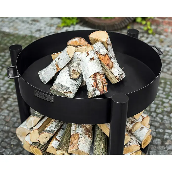 CookKing Feuerschale Montana - Ø x H: 88 x 80 cm, Stahl - Schwarze Metall-Feuerschale mit doppelter Ebene, Birkenholz auf Kopfsteinpflaster.
