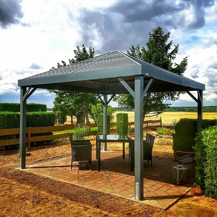 Sojag Standard-Pavillon Premium South Beach 1212 - Basaltgrau, Aluminium, B x T: 364,3 x 364,3 cm - Anthrazitfarbener Metallpavillon mit grauem Dach, über einer Outdoor-Essgruppe auf gepflasterter Terrasse.