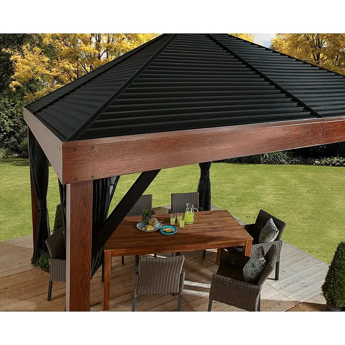 Sojag Standard-Pavillon Premium South Beach 1212 - B x T: 34,3 x 364,3 cm, Braun, Aluminium - Dunkelbrauner Holzpavillon mit schwarzem Wellblechdach und schwarzen Netzvorhängen auf einer Holzterrasse mit Esstisch und Stühlen.