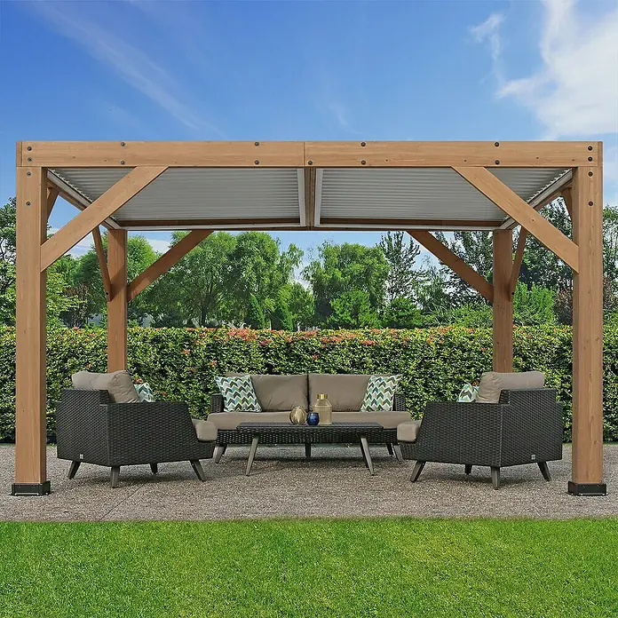Westmann Pergola Karl - B x T: 335 x 396 cm, Braun, Holz - Holzpergola mit Wellblechdach über einer dunkelgrauen Rattan-Sitzgruppe mit hellen Kissen und Couchtisch auf einer Terrasse.