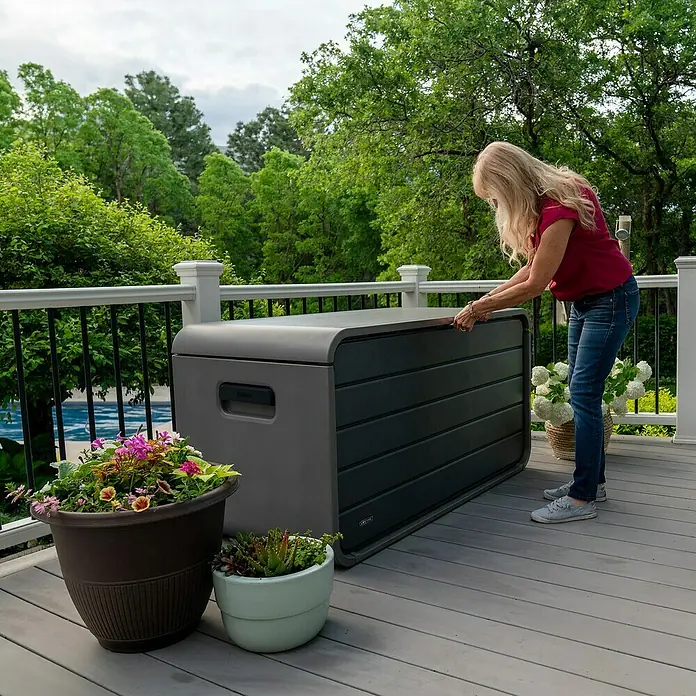 Aufbewahrungsbox Space XL - B x T x H: 146,7 x 72,4 x 77,2 cm, Kunststoff, Anthrazit - Frau öffnet eine dunkelgraue Outdoor-Aufbewahrungsbox auf einer Terrasse.