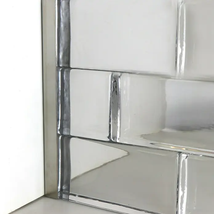 Fuchs Design Glasbausteinprofil - Edelstahl, Gebürstet, 200 x 5,6 x 2,5 cm - Nahaufnahme eines weißen, glänzenden Fliesenmusters, das die Lichtreflexion und die Textur des Materials hervorhebt. Ideal für moderne Badezimmer.