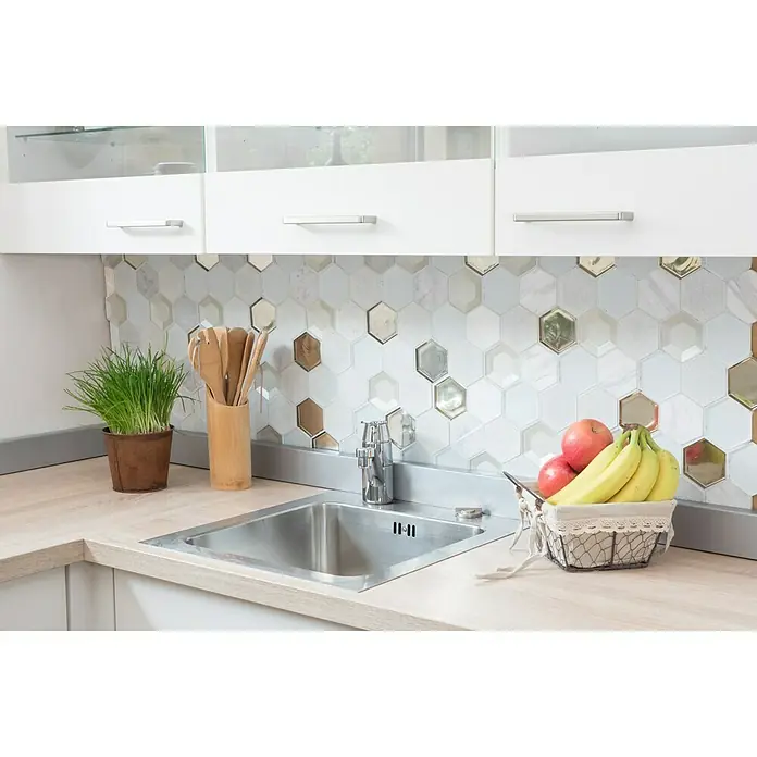 Mosaikfliese Hexagon HXN 66 - 26,5 x 30,5 cm, Weiß, Glänzend - Küchenspüle aus Edelstahl mit Armatur, umgeben von einer Arbeitsplatte mit Obstkorb, Kräutern und Utensilienbehälter vor Fliesenspiegel.