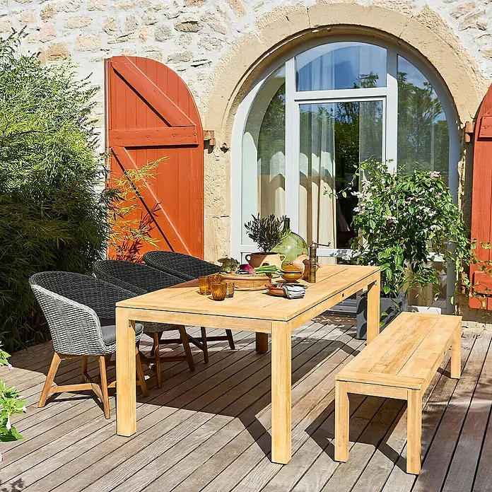 Sunfun Gartenmöbel-Set Laura/Pauline - 5 -tlg., Braun/Grau - Ein Gartentisch-Set aus Holz mit Stühlen und einer Bank auf einer Holzterrasse vor einem Haus mit Fenster und Fensterläden.