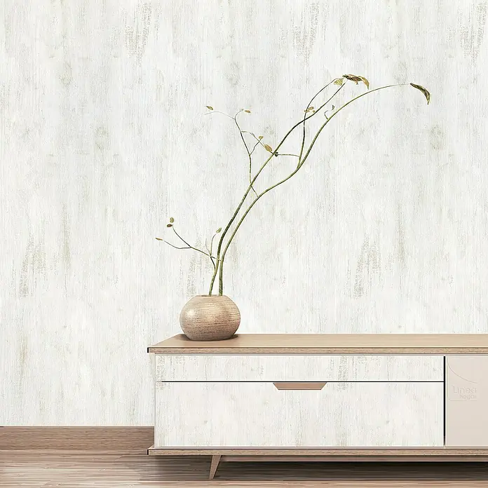 Lámina decorativa autoadhesiva vinílico Premium - 90 x 280 cm, Chalky, Gris - Primer plano de un mueble bajo moderno con un jarrón y ramas delicadas sobre una pared blanca texturizada.