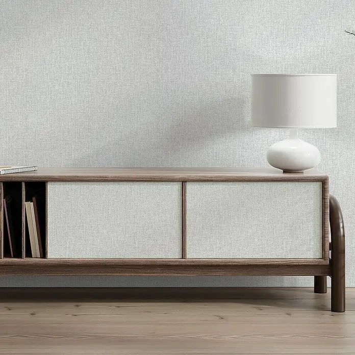 Lámina decorativa autoadhesiva vinílico Premium - 90 x 280 cm, Lienzo, Gris - Escena de interior con un aparador de madera con inserciones de tela y una lámpara blanca encima.