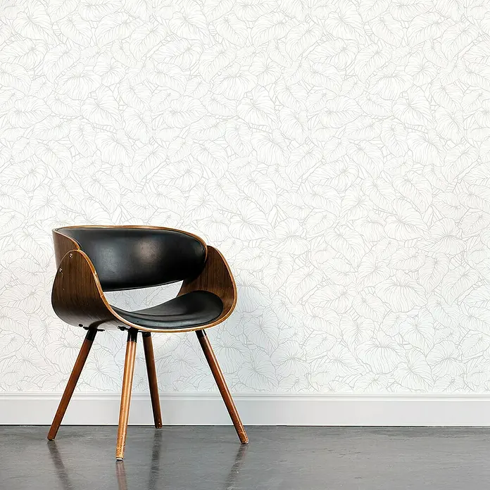 Lámina decorativa autoadhesiva vinílico Premium - 90 x 280 cm, India, Blanco - Elegante silla con carcasa de madera y asiento de cuero negro, frente a una pared con diseño de hojas, ideal para cualquier espacio moderno.