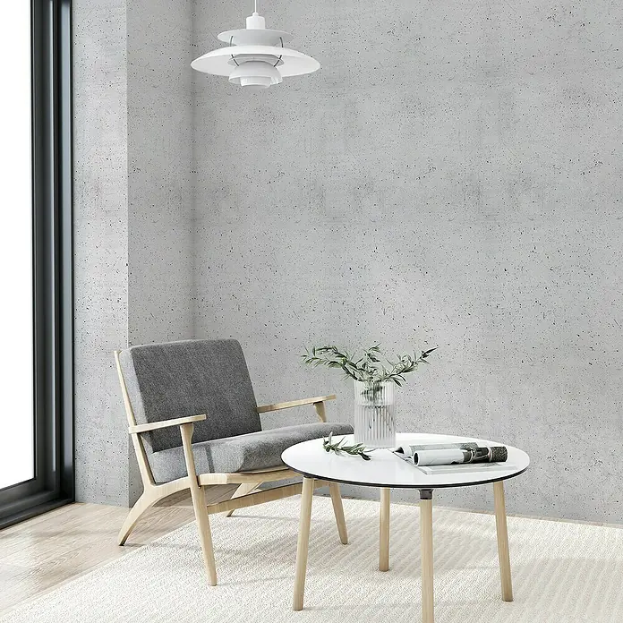 Lámina decorativa autoadhesiva vinílico Premium - 90 x 280 cm, Hormigón, Gris - Acogedor rincón de lectura con un elegante sillón gris, una mesa redonda con jarrón de flores y una lámpara colgante moderna. Minimalista y acogedor.