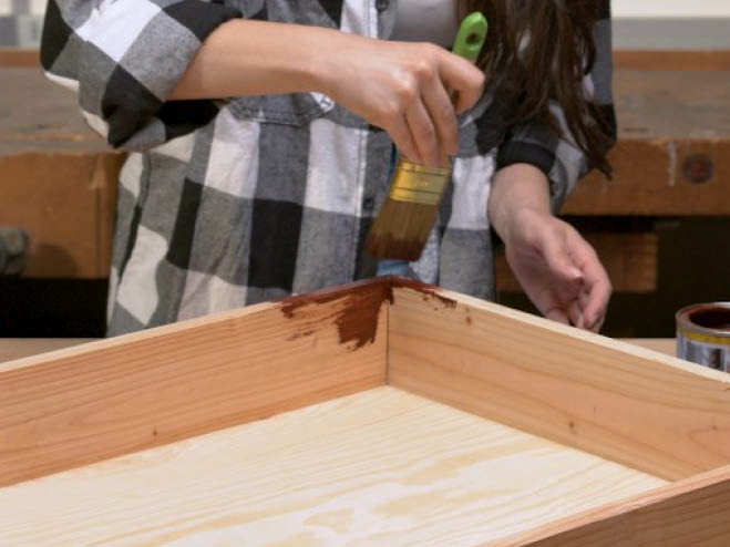 Der DIY Regalrahmen wird mit Dekorwachs in dunkelbraun angestrichen 