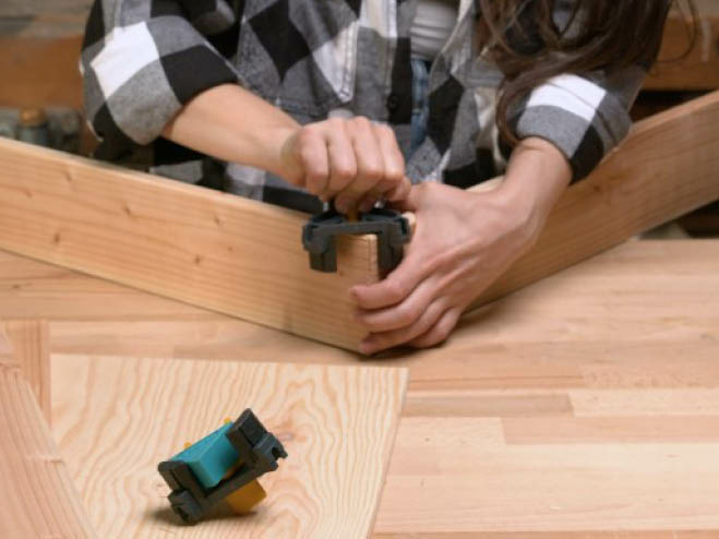 2 Holzbretter werden an den Kanten mit einem Eckspanner zu einem Rahmen verbunden