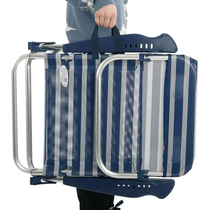 Silla de camping Nora - An x Pr x Al: 67 x 57 x 85 cm, Azul/Blanco, Aluminio/Textiline - Silla de playa plegada a rayas con estructura plateada y asa de transporte sujeta por una persona.