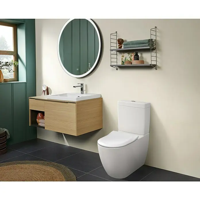 Villeroy & Boch Subway 3.0 Stand-WC-Kombination - Spülrandlos, Mit schmutzabweisender Glasur, Spülform: Tief, WC Abgang: Waagerecht, Weiß Alpin - Modernes Badezimmer mit weißer Toilette und hellem Holzwaschtisch mit weißem Waschbecken. Ein beleuchteter Spiegel und Regale ergänzen den Raum.