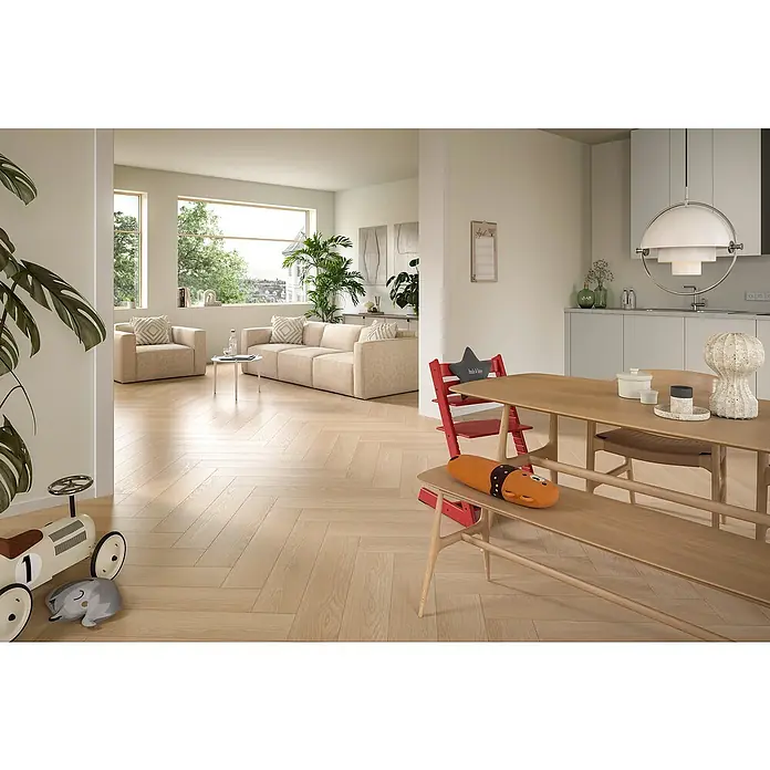 Egger Laminat NatureSense Herringbone - Baronia Eiche sand, Fischgrät, 840 x 168 x 8 mm - Helles Wohnzimmer mit modernem Holztisch und Kinderstuhl. Der Tisch dient als zentraler Punkt, umgeben von stilvoller Einrichtung.