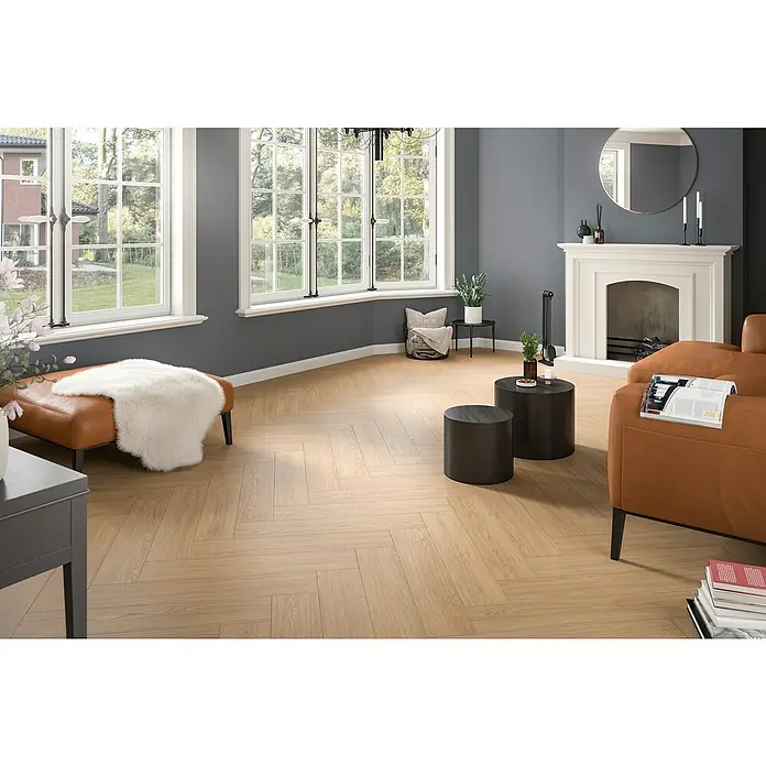 Egger Laminat NatureSense Herringbone - Casella Eiche natur, Fischgrät, 840 x 168 x 8 mm - Ein helles Wohnzimmer mit einem hellbraunen Parkettboden in Fischgrätmuster, der dem Raum Wärme und Eleganz verleiht.