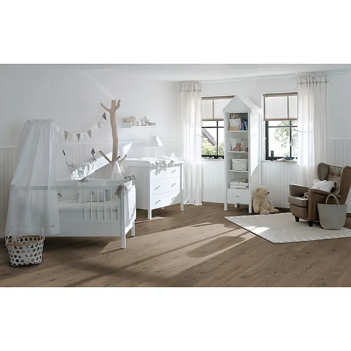 Egger Laminat NatureSense - Murom Eiche natur, Landhausdiele, 1.292 x 193 x 8 mm - Kinderzimmer mit weißem Kinderbett, Wickelkommode und Bücherregal in Hausform, ergänzt durch einen braunen Sessel und einen hellen Teppich.