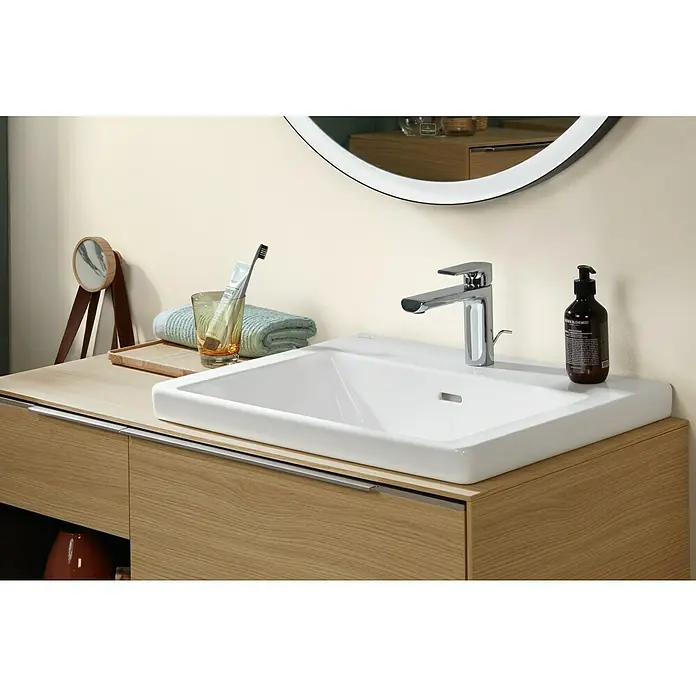 Villeroy & Boch Subway 3.0 Waschtisch - 60 x 47 cm, Mit schmutzabweisender Glasur, Hahnloch: Mitte, Mit Überlauf, Stone White, Ungeschliffen, Waschbecken geeignet für: Halbsäule - Moderner Badezimmerschrank aus hellem Holz mit integriertem weißen Keramikwaschbecken und Chromarmatur, komplett mit Toilettenartikeln und einem runden Spiegel.
