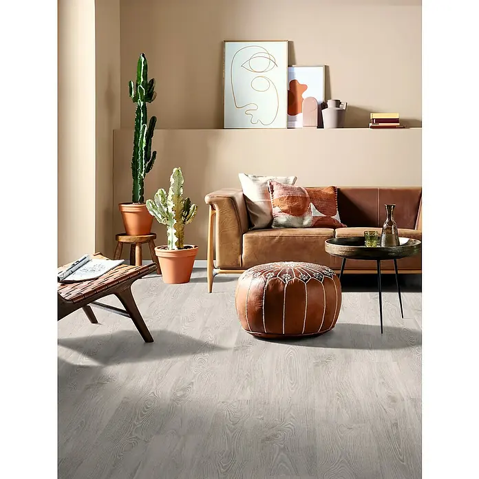 Egger Laminat NatureSense - Girona Kastanie weiss, Landhausdiele, 1.292 x 193 x 8 mm - Einladender Wohnraum mit modernem Touch, hervorgehoben durch einen eleganten Ledersitzhocker und einen passenden Couchtisch.
