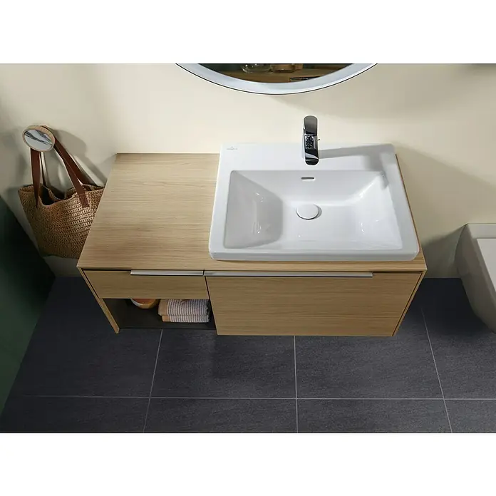 Villeroy & Boch Subway 3.0 Waschtisch - 60 x 47 cm, Mit schmutzabweisender Glasur, Hahnloch: Mitte, Mit Überlauf, Stone White, Ungeschliffen, Waschbecken geeignet für: Halbsäule - Moderne Badmöbel von oben: weißes, rechteckiges Waschbecken, Chromarmatur, heller Holzunterschrank mit Schubladen, auf dunklen Fliesen.