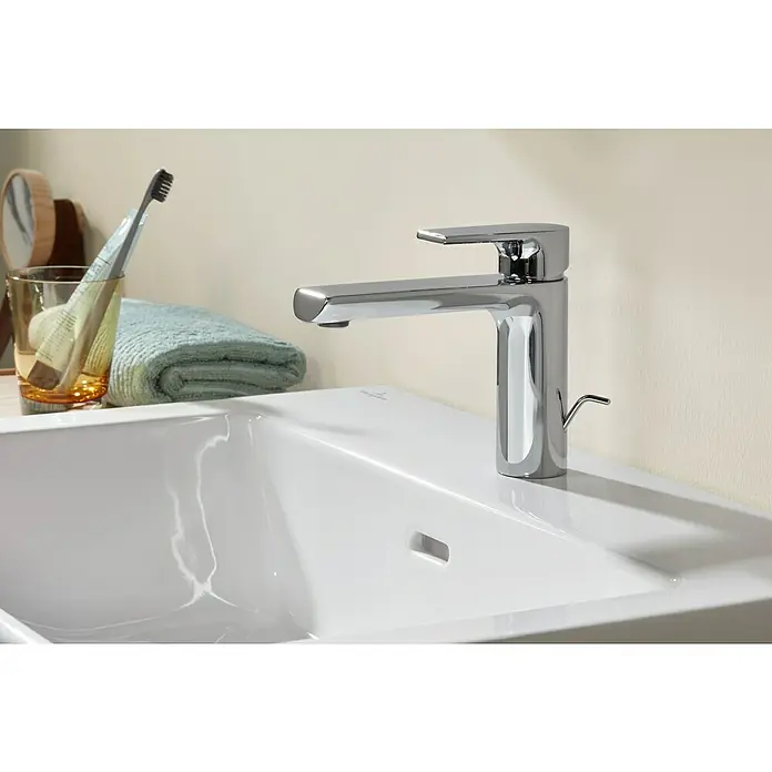 Villeroy & Boch Subway 3.0 Waschtisch - 60 x 47 cm, Mit schmutzabweisender Glasur, Hahnloch: Mitte, Mit Überlauf, Stone White, Ungeschliffen, Waschbecken geeignet für: Halbsäule - Chromarmatur auf einem weißen Keramikwaschbecken im Bad, mit Zahnbürste und Handtuch daneben.