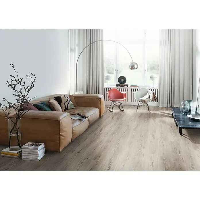 Egger Laminat NatureSense - Melba Eiche grau, Landhausdiele, 1.292 x 193 x 7 mm - Modernes Wohnzimmer mit einem großen beigen Sofa, einem eleganten Bogenlampe und hellem Holzboden, der eine warme Atmosphäre schafft.