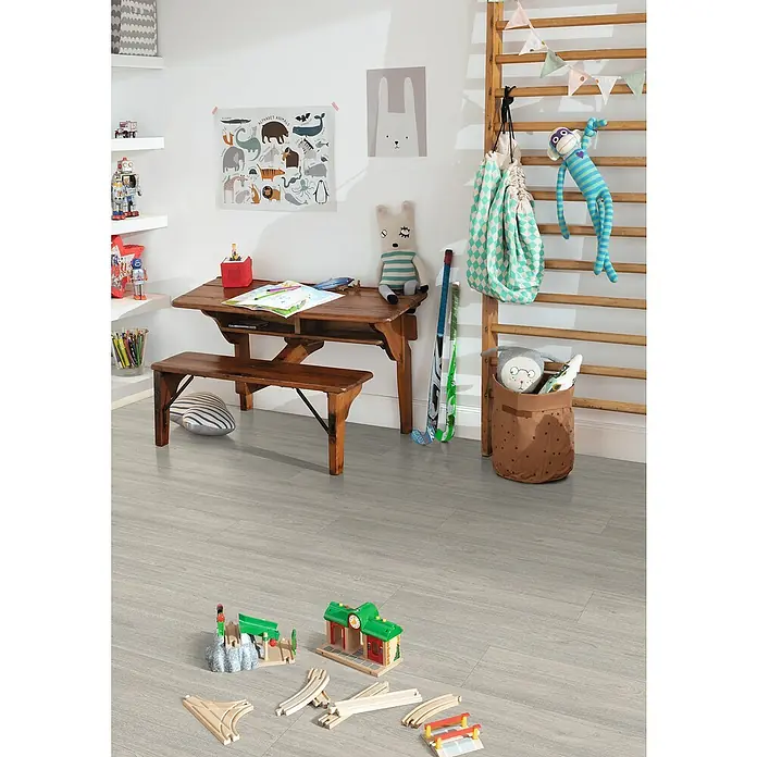 Egger Laminat NatureSense - Charlotte Eiche hellgrau, Landhausdiele, 1.292 x 193 x 7 mm - Helles, modernes Kinderzimmer mit Spielzeug auf grauem Holzboden. Ein Holzschreibtisch und eine Sprossenwand ergänzen den Raum.
