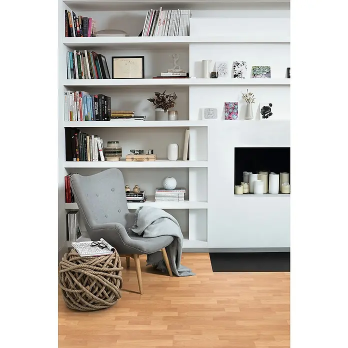 Egger Laminat NatureSense - Buche SB rustikal, Schiffsboden, 1.292 x 193 x 7 mm - Bücherregal mit Dekorationen und einem Sessel.