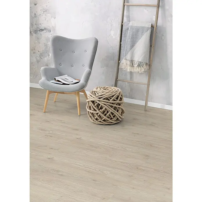 Egger Laminat NatureSense - Ashcroft Wood, Landhausdiele, 1.292 x 193 x 8 mm - Das Bild zeigt einen hellgrauen Sessel mit Knöpfen und eine dekorative Kugel aus Seil in einem modern eingerichteten Raum.