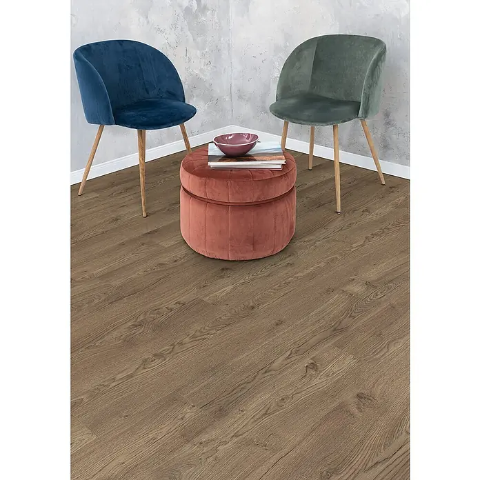 Egger Laminat NatureSense Aqua - Olchon Eiche rauch, Landhausdiele, 1.292 x 193 x 10 mm - Elegante Inneneinrichtung mit zwei Stühlen und einem rosa Ottomanen auf einem warmen Holzboden.