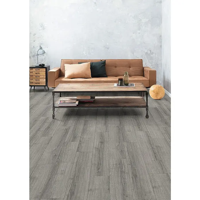 Egger Laminat NatureSense Aqua - Sherman Eiche hellgrau, Landhausdiele, 1.292 x 193 x 8 mm - Einrichtung mit einem Couchtisch, einer Couch und einem Bodenbelag. Der Bodenbelag ist aus Holzimitat in grauer Farbe, passend zum Interieur.