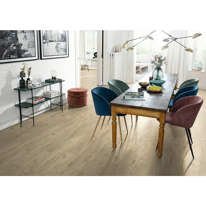Egger Laminat NatureSense Aqua - Olchon Eiche sandbeige, Landhausdiele, 1.292 x 193 x 8 mm - Dieses Bild zeigt einen Essbereich mit einem Holztisch, umgeben von farbigen Stühlen, der den rustikalen Charme und das elegante Design vereint.