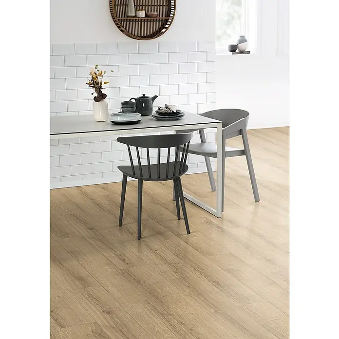 Egger Laminat NatureSense Aqua - Sherman Eiche hellbraun, Landhausdiele, 1.292 x 193 x 10 mm - Dieses Bild zeigt einen hellen Holzboden mit zwei Stühlen und einem Esstisch, der eine moderne und stilvolle Einrichtung präsentiert.