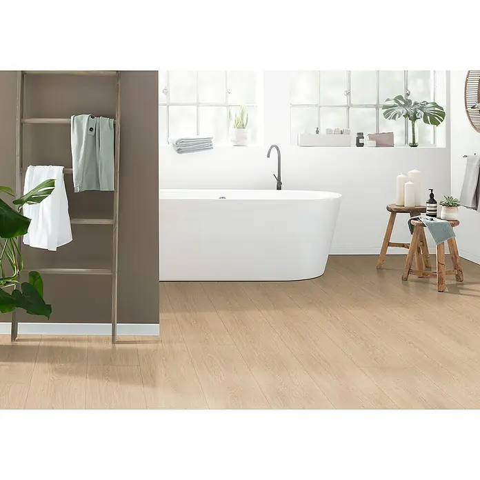 Egger Laminat NatureSense Aqua - Victoria Eiche natur, Landhausdiele, 1.292 x 246 x 8 mm - Badezimmer mit freistehender Badewanne und hellem Holzboden. Dekorative Leiter mit Handtüchern und Pflanzen für eine entspannende Atmosphäre.