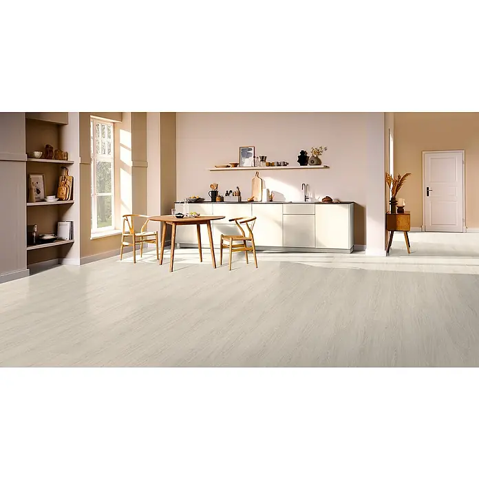 Egger Laminat NatureSense Aqua - Victoria Eiche weiß, Landhausdiele, 1.292 x 246 x 8 mm - Ein helles, modernes Interieur mit einem Esstisch aus Holz und einer minimalistischen Küchenzeile, hervorgehoben durch einen hellen Bodenbelag.