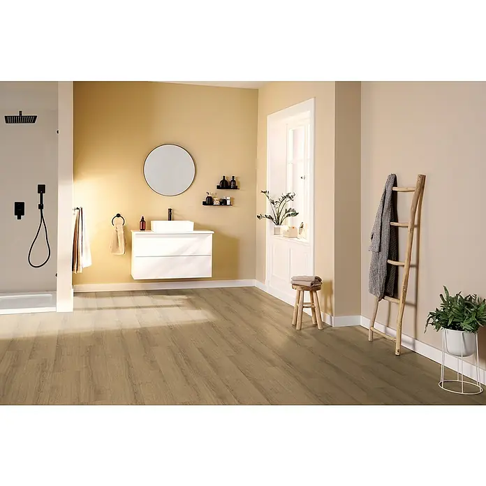Egger Laminat NatureSense Aqua - Sherman Eiche honig, Landhausdiele, 1.292 x 193 x 8 mm - Helles Badezimmer mit Holzboden, weißem Waschtisch mit runden Spiegel, Dusche mit schwarzer Duscharmatur und Holzleiter mit Handtuch.