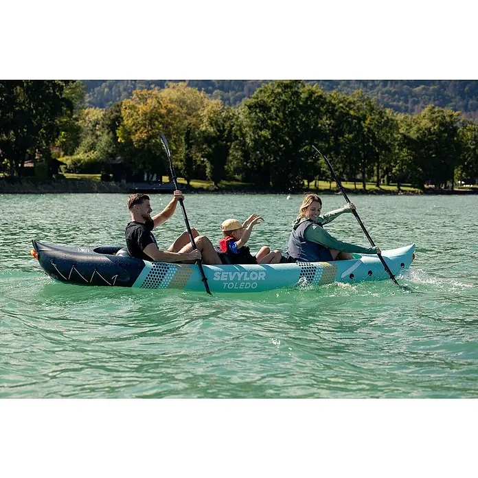 Sevylor Kajak Toledo - L x B: 361 x 90 cm, Nutzlast: 200 kg, Geeignet für: 2+1 Personen - Familie paddelt im Sevylor Toledo Kajak auf einem See. Das aufblasbare Kajak bietet Platz für zwei Erwachsene und ein Kind.